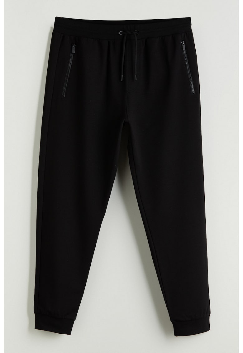 Pantaloni conici de trening cu buzunare cu fermoar Pantaloni conici de trening cu buzunare cu fermoar