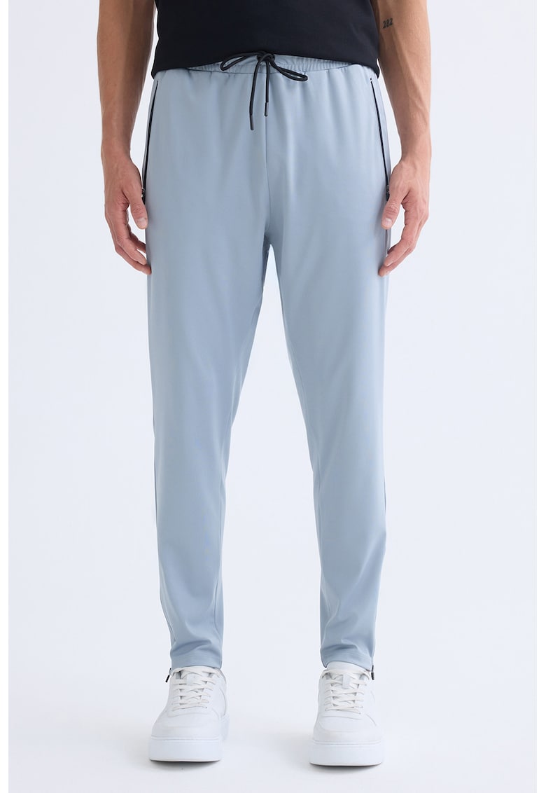 Pantaloni de trening cu croiala conica si buzunare cu fermoar