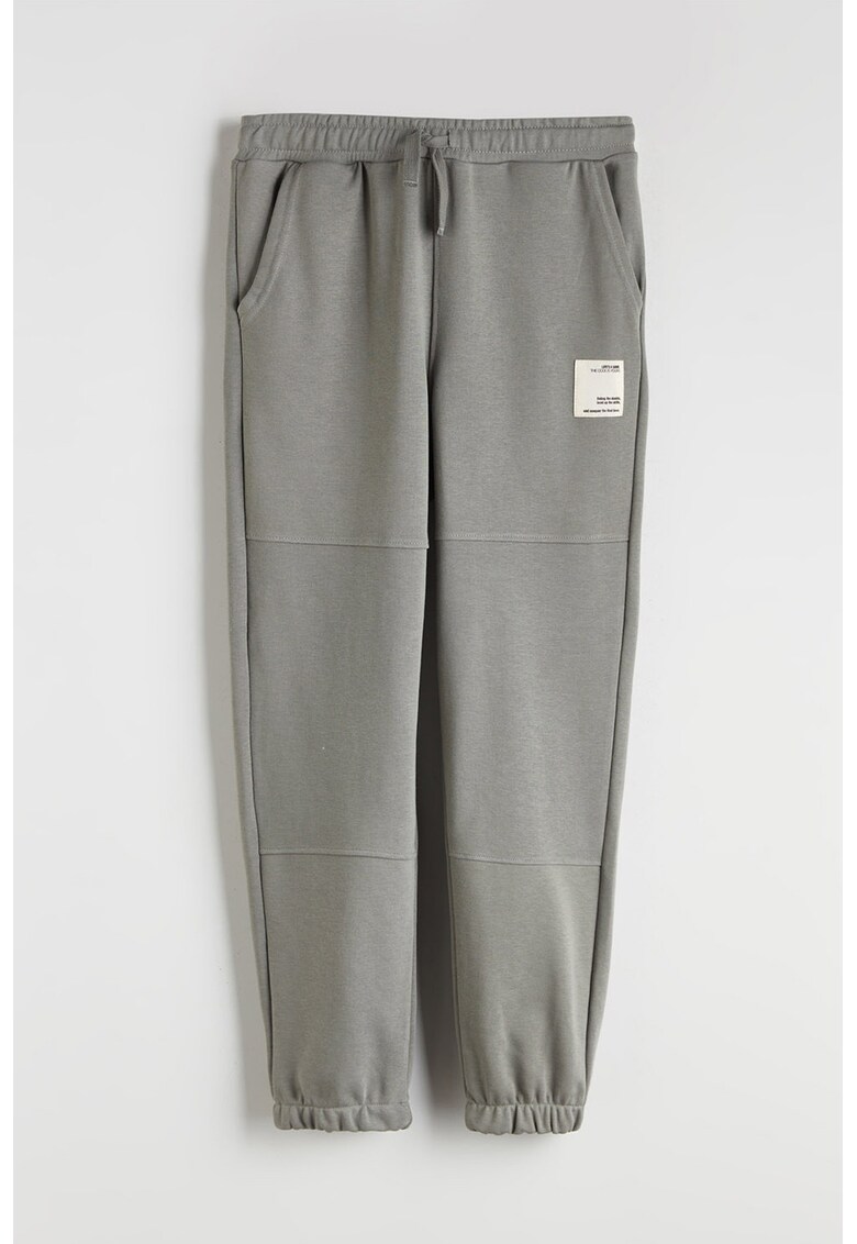 Pantaloni conici de trening cu buzunare oblice