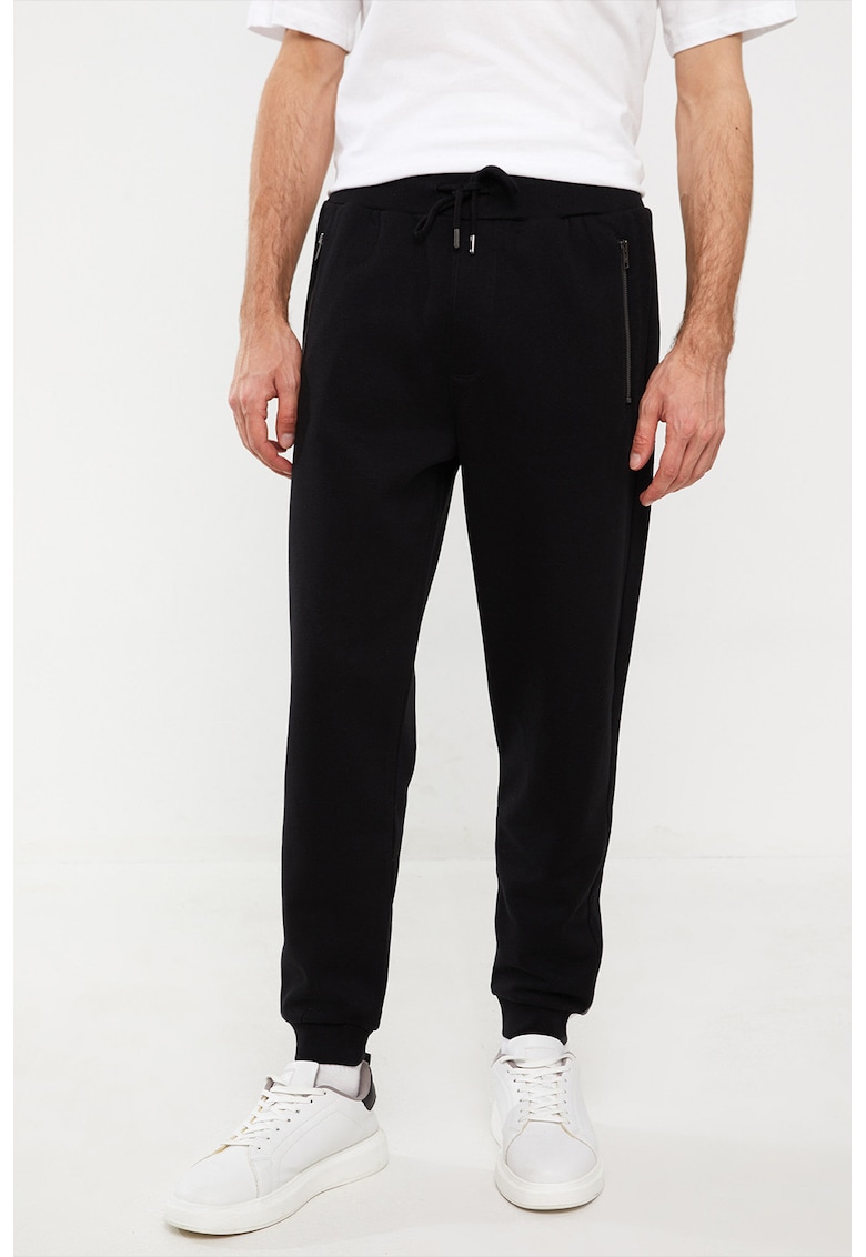 Pantaloni de trening cu croiala conica cu buzunare cu fermoar