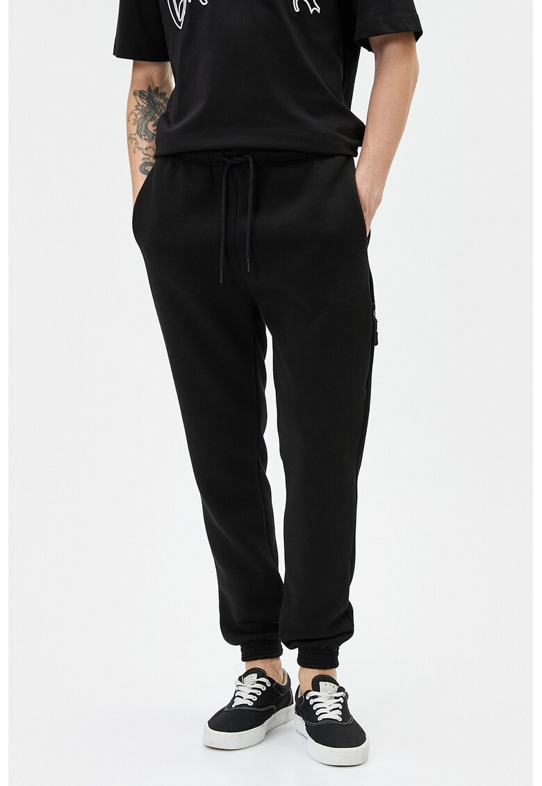 Pantaloni de trening cu croiala conica si snur de ajustare in talie