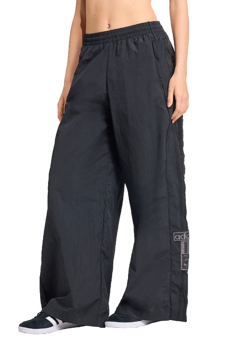 Pantaloni de trening cu croiala ampla si capse laterale